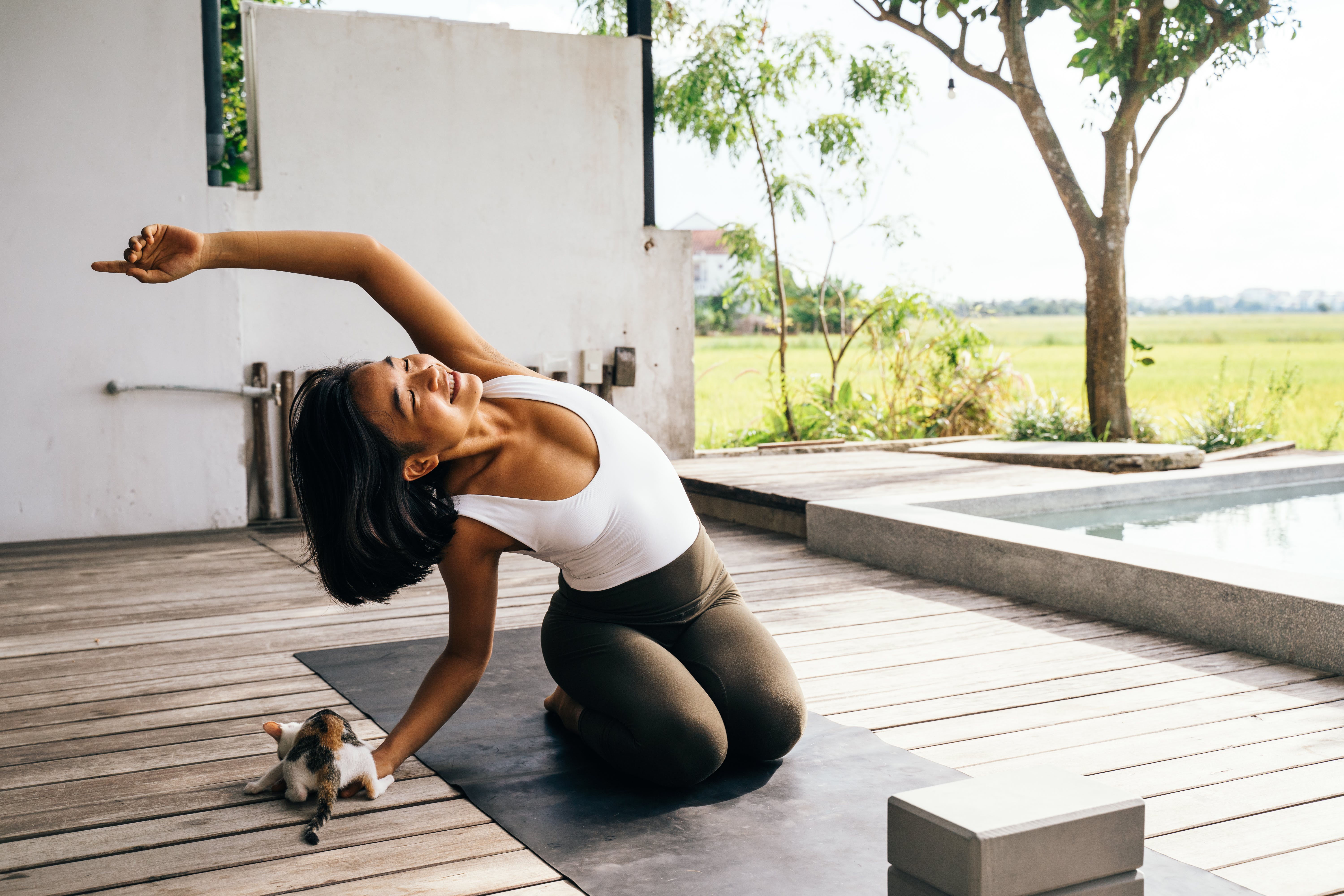 Woman stretching outdoors with cat
