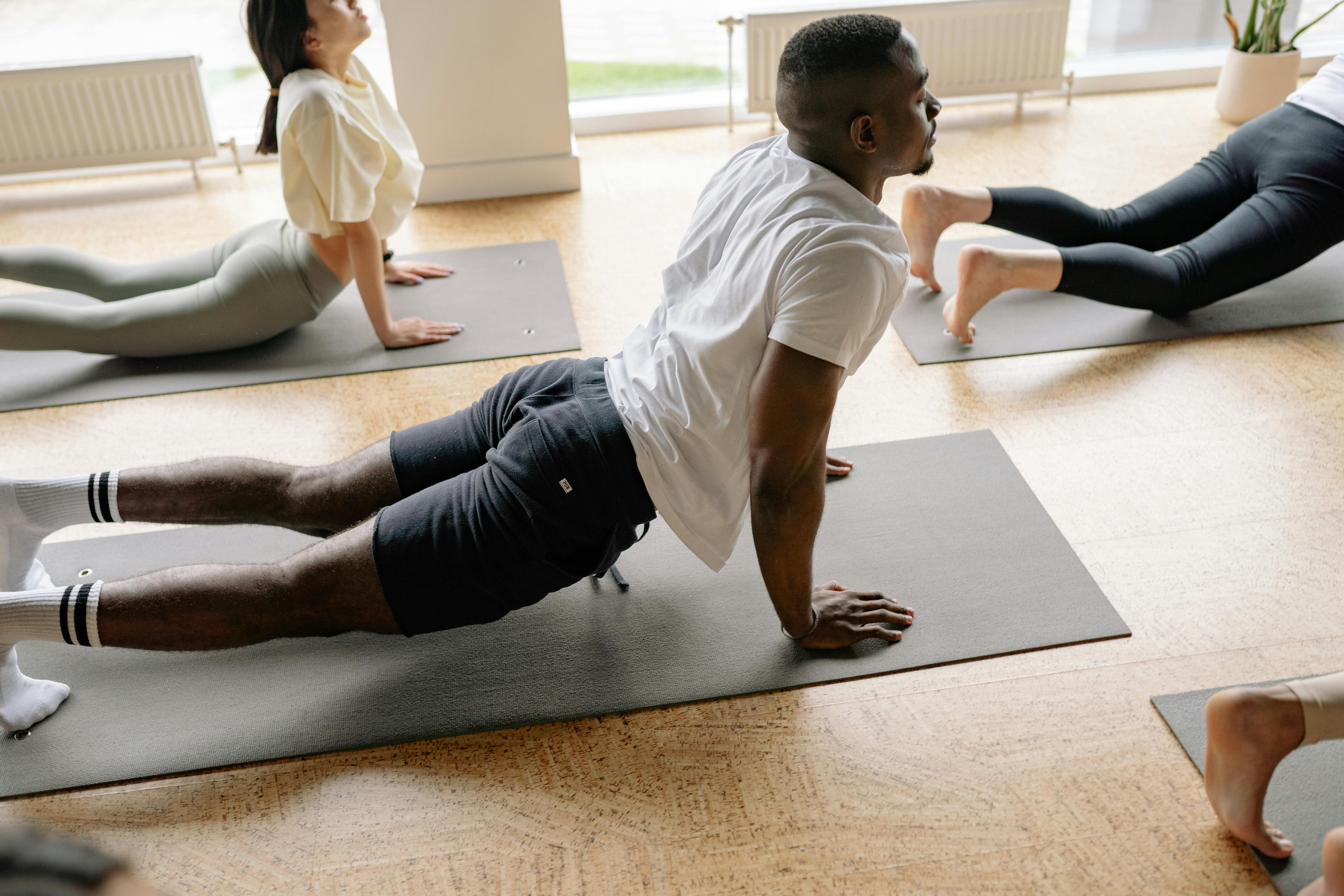 A group of people doing a yoga pose on a yoga mat